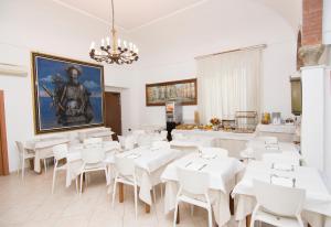 a dining room with white tables and white chairs at Hotel Fontana in Amalfi