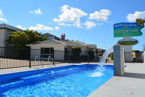 a swimming pool with a water fountain at Rocky Gardens Motor Inn Rockhampton in Rockhampton