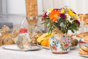 a vase filled with flowers on a table with food at Hotel Fontana in Amalfi