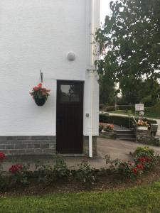 Biały dom z drzwiami i doniczką w obiekcie Au logis fleuri w mieście Francorchamps