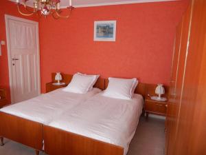 フランコルシャンにあるAu logis fleuriのベッドルーム1室(オレンジ色の壁のベッド1台付)