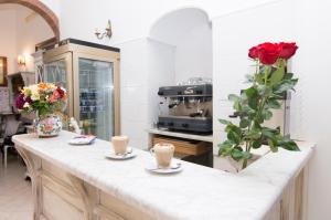 a kitchen with a counter with two cups and roses at Hotel Fontana in Amalfi