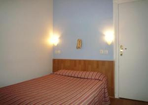 a bedroom with a bed and two lights on the wall at Hôtel Du Brabant in Paris