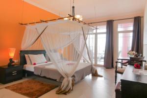 a bedroom with a bed with a mosquito net at Villa Fleur De Lys in Makunduchi