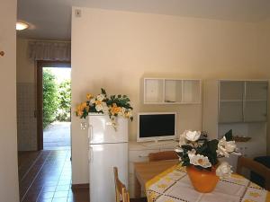 a kitchen with a table and a refrigerator with flowers on it at Capri in Bibione