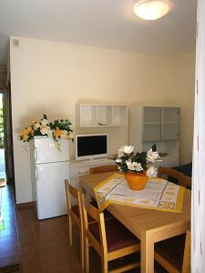 a kitchen and dining room with a table and a refrigerator at Capri in Bibione