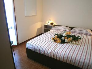 a bed with a bouquet of flowers on it at Capri in Bibione