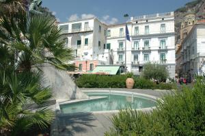 a small pool in the middle of a city with buildings at Hotel Fontana in Amalfi