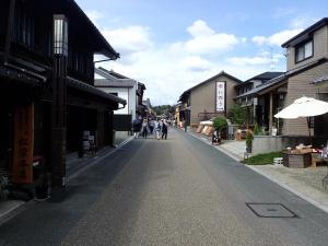 a street in a town with people walking down the street at Castle Inn Komaki in Komaki