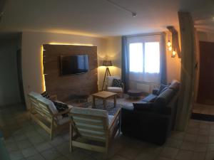 a living room with a couch and a tv at Domaine de la Loge in Flacey-en-Bresse +19 photos