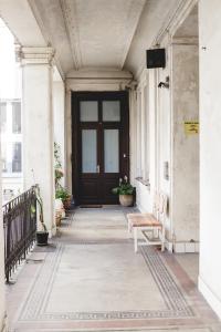 un porche con una puerta de madera y un banco en Urban Rooms en Budapest