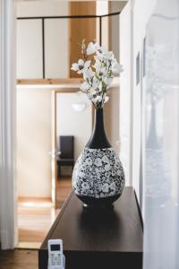 un jarrón blanco y negro con flores en una mesa en Urban Rooms, en Budapest
