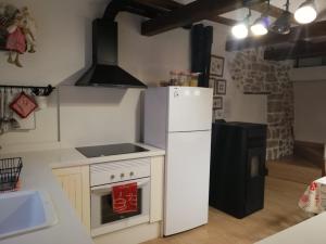 a kitchen with a white refrigerator and a stove at La Casita del Castillo in Mora de Rubielos