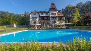a large house with a swimming pool in front of it at Landhaus Koller in Gosau