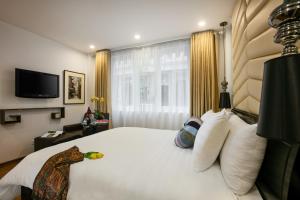 a bedroom with a bed and a television at Splendid Star Grand Hotel and Spa in Hanoi