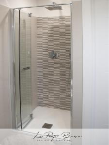 una ducha con puerta de cristal en un baño en La Porta Bianca, en Trieste