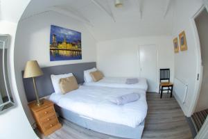 a bedroom with two beds and a table and a lamp at Liberty Townhouses in Dublin