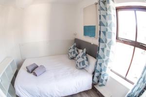 a small bed in a small room with a window at Liberty Townhouses in Dublin