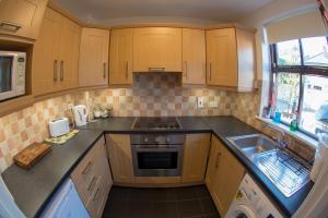 a small kitchen with wooden cabinets and a sink at Liberty Townhouses in Dublin