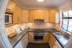 a kitchen with wooden cabinets and a sink at Liberty Townhouses in Dublin