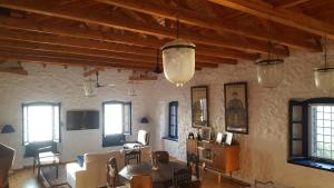 a living room with tables and chairs and windows at The Villa of Blues in Kalamata