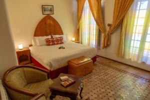1 dormitorio con 1 cama y 1 silla en una habitación en Riad Tahra & Spa, en Fez