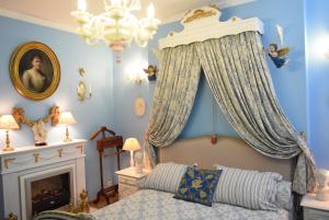 Schlafzimmer mit blauen Wänden, einem Bett und einem Kronleuchter in der Unterkunft Boutique B&B Poppy's in Brügge