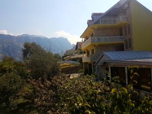een groot geel gebouw met bergen op de achtergrond bij Apartment Ksenija in Kotor