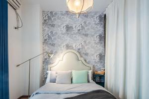 a bedroom with a bed with a gray wall at Chengdu Qingyang·Southwestern University of Finance And Economics Locals Apartment 00154480 in Chengdu