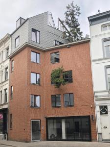 un edificio de ladrillo rojo con techo gris en B&B Lucy in the Sky en Amberes