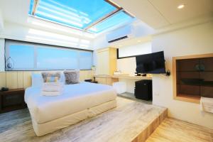 a bedroom with a bed and a flat screen tv at Laguna Villas & Resorts in Magong