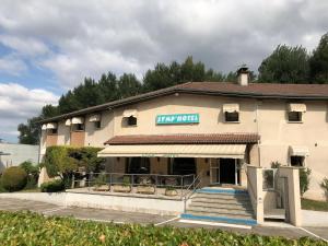 un edificio con un cartel en la parte delantera en Symp'Hotel en Nivolas-Vermelle