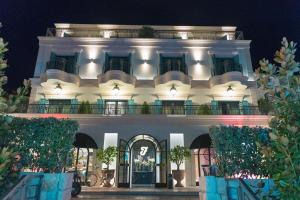 a large white building with a balcony at night at Hotel Forza Terra in Kotor