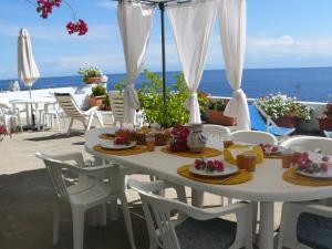a white table with plates of food on a balcony at Casa Athena in Lipari
