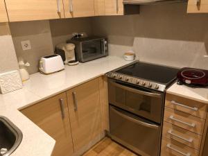 a kitchen with a stove and a microwave at Céntrico Apartamento. Parking incl. in Vigo