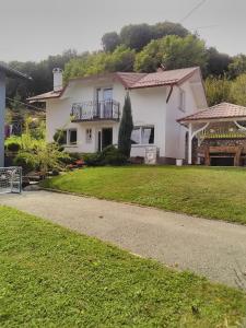 a white house with a lawn and a driveway at Apartman Lara in Krapina