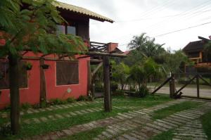 a house with a fence in front of a yard at Cabanas Aconchegantes próximas ao mar in Garopaba