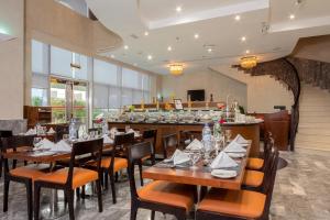 a restaurant with wooden tables and chairs and a bar at City Premiere Hotel Apartments - Dubai in Dubai