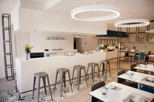 un restaurante con mostrador blanco y taburetes en Hôtel Du Port, en Morlaix