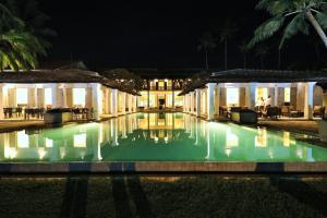 a swimming pool in front of a building at night at Era Beach in Unawatuna