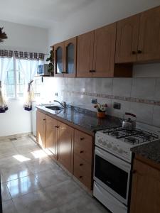 cocina con armarios de madera y horno con fogones en DUPLEX DEVoTO 5238 en Buenos Aires