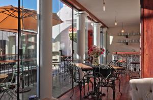 comedor con mesas y sillas en el balcón en On Hotel Boutique, en Sucre