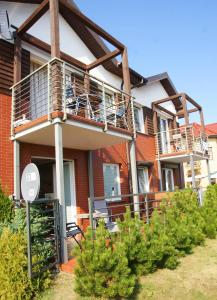 un edificio de apartamentos con balcón y algunos arbustos en Apartament Słoneczny, en Sarbinowo