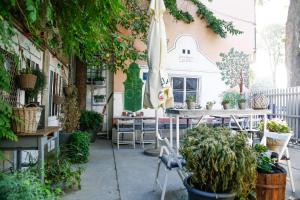 a patio with a table and chairs and plants at City Hostel in Novi Sad