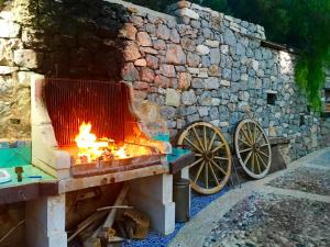a stone oven with a fire in it next to a stone wall at Villa Di Maria in San Vito lo Capo