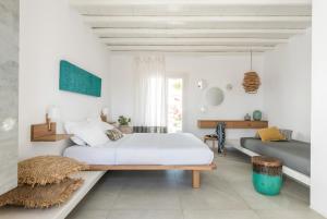 a white bedroom with a bed and a couch at A Hotel Mykonos in Mýkonos City