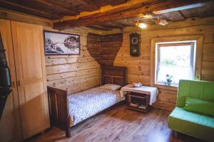 a bedroom in a log cabin with a bed and a table at Sokolskie Chaty in Gorlice