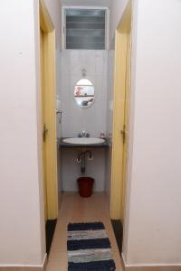 a small bathroom with a sink and a mirror at Sri Vana Durga Service Apartment in Sringeri