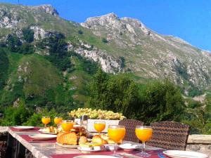 a table with plates of food and glasses of orange juice at La Casona de Sames in Sames