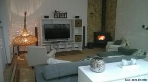 a living room with couches and a tv and a fireplace at Casa da Lameira in Serra